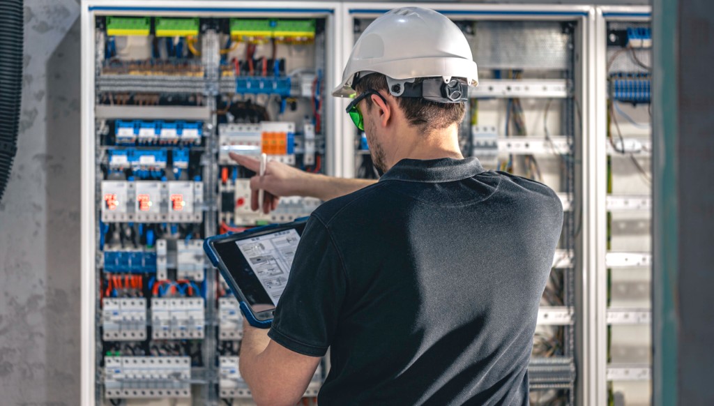 An electrician checking an open switchboard